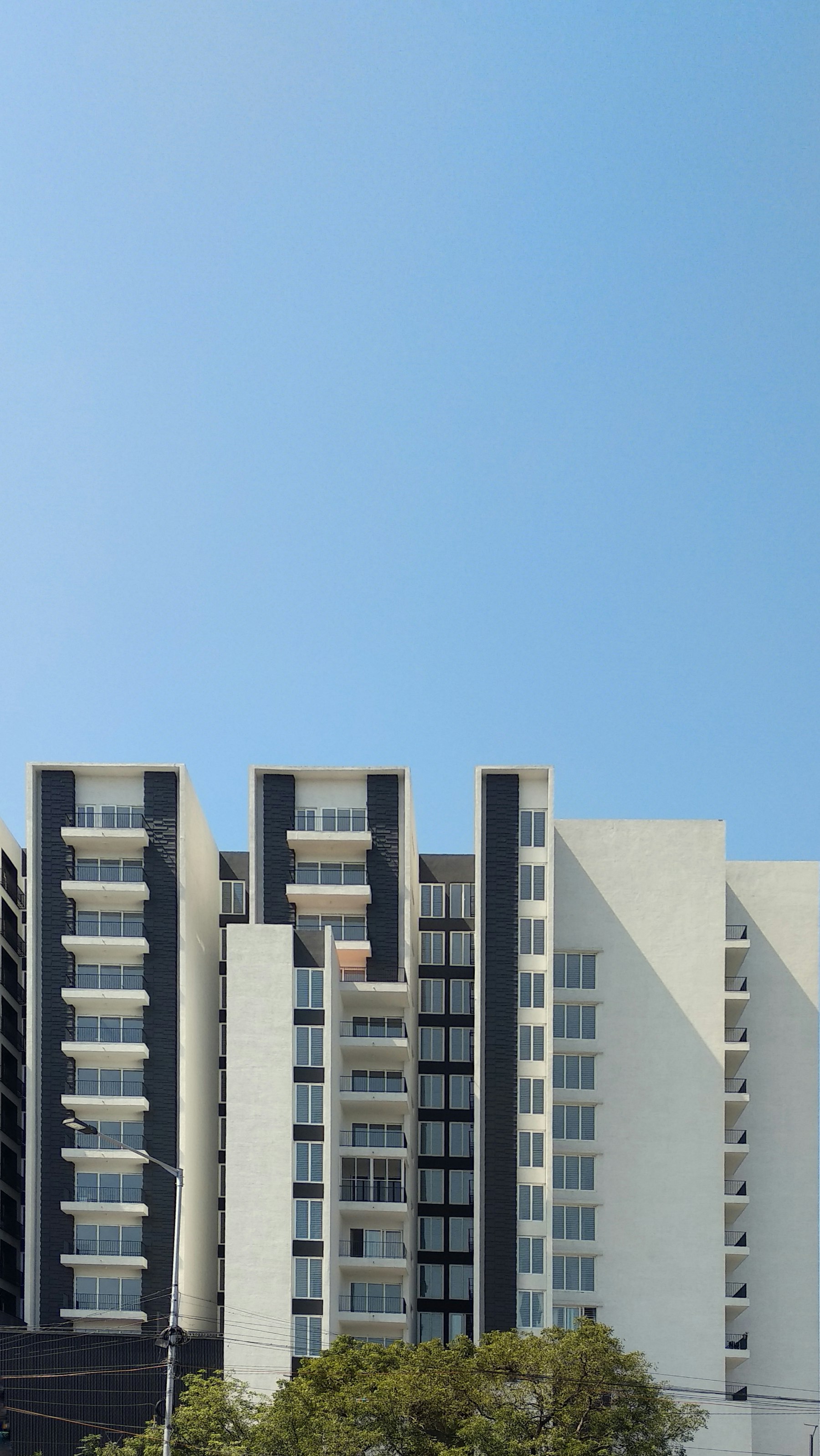 White multifamily apartment building against a clear sky